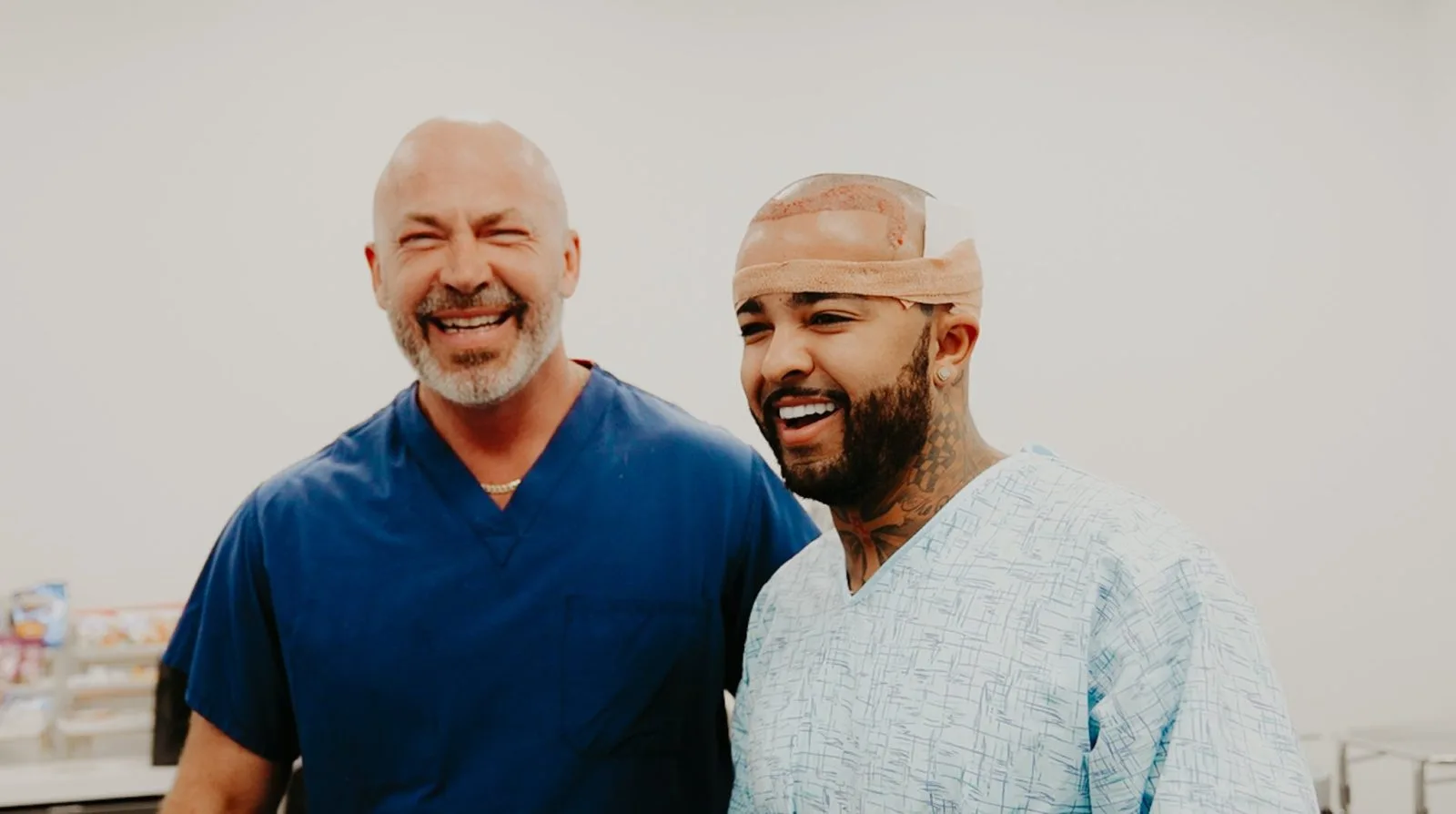 Two smiling men in medical scrubs posing together in a clinical setting